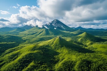 Fototapeta premium Majestic volcanic peaks rise above lush green valleys under a brilliant blue sky in a breathtaking natural landscape