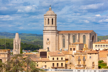 Obraz premium The bell tower of the cathedral rises above traditional stone buildings Spain, Catalonia