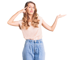 Young beautiful caucasian woman with blond hair wearing casual clothes confused and annoyed with open palm showing copy space and pointing finger to forehead. think about it.
