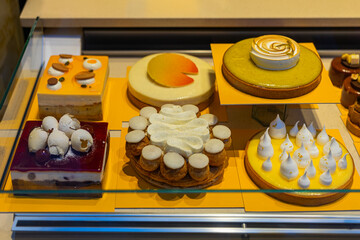 Assortment of cakes displayed in bakery. Concept of luxury desserts and culinary craftsmanship