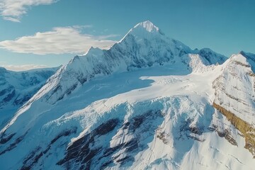 Snow-capped peaks rise majestically under a clear blue sky in a breathtaking alpine landscape captured at dawn