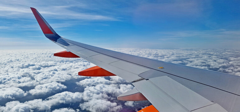 View through the window of a commercial airplane flying over clouds sky