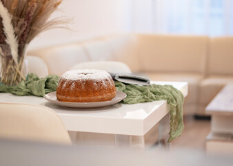 Fresh homemade baked bundt cake on the table in the dining room. Yummy cake sprinkeled with powder sugar. Delicious sweet breakfast.