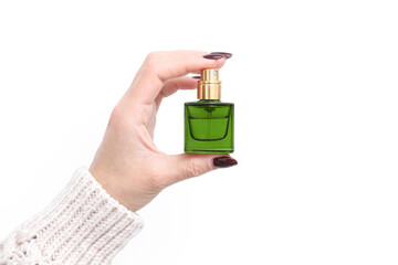 Woman's hand holding perfume bottle. Elegant crystal fragrance atomizer isolated on white...