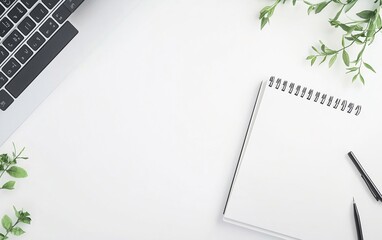 Modern workspace with laptop, notepad, and greenery on white desk. Minimalist office setup for productivity. Clean business background with copy space