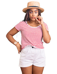 Young african american woman with braids wearing summer hat mouth and lips shut as zip with...