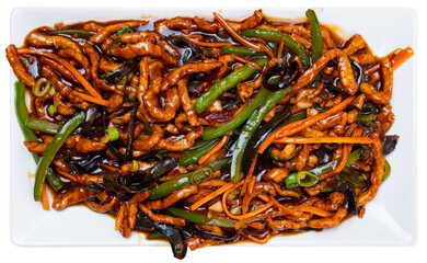 Chinese cuisine dish - appetizing yuxiang shredded pork with carrots and green beans served on plate. Isolated over white background