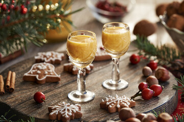 Two shot glasses of Eiecognac with Christmas decoration and gingerbread cookies