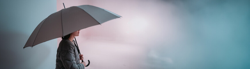 Minimalistic portrait of a girl with an umbrella on a uniform background. The concept of security...