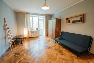 The interior of the apartment. A bright room with a minimum of furniture. Housewarming. The apartment is for rent.
