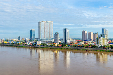 Obraz premium Tonle Sap river bank with modern buildings and residential areas distric in the background, Phnom Penh city panorama, Cambodia