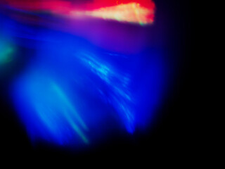 A colorful, blurry background with a rainbow of colors. The colors are bright and vibrant, creating a sense of energy and excitement. Abstract design wall paper. Cinematic light effect.