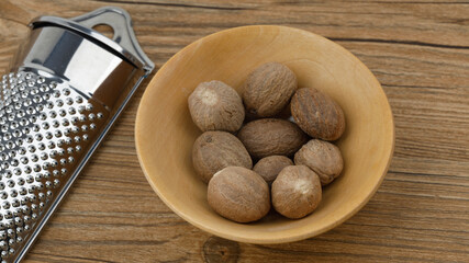 Nutmeg grater with nutmegs in a small wooden bowl