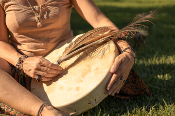 young woman playing shamanic drum