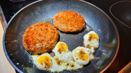 frying pan with meat and eggs