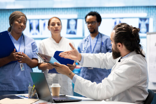 Doctor specialist reviewing human anatomy scans to ensure effective treatment plans. Team of licensed healthcare experts working together to provide comprehensive medical services at a clinic.