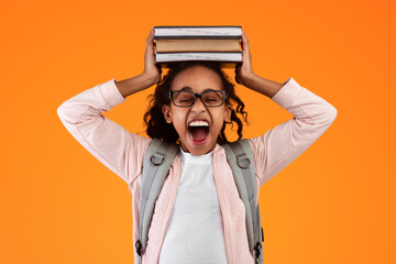 A Lot Of Homework. Portrait of tired black student girl putting and holding pile of academic books...