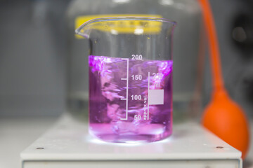 Purple liquid swirling in a beaker during a lab experiment