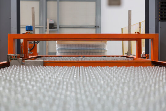 Conveyor system moving glass bottles in a factory