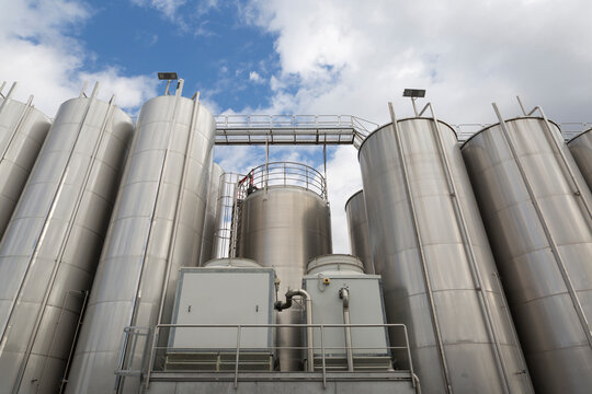 Industrial Stainless Steel Tanks Against Blue Sky