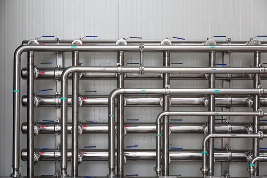 Stainless steel industrial pipes with valves in a factory