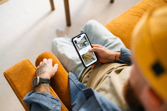 A man uses a mobile phone at home