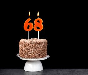 Birthday cake with number 68 candle - Anniversary card on a black background