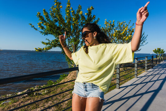 Fun latina woman skating and dancing at the park portrait