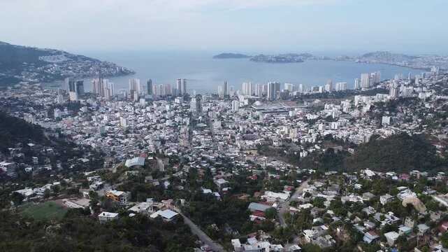 Aerial zoom out of the bay of Acapulco to the hils.
