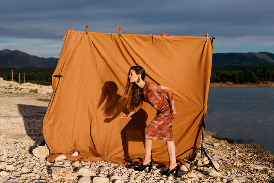 Woman standing near curtain in bright light