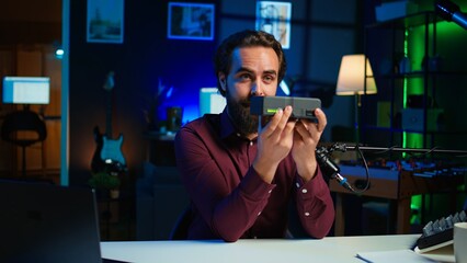 Portable V mount battery presented by knowledgeable tech professional to audience in studio. Lithium li ion charging device held by content creator doing presentation, camera B