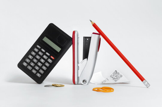 Still life with calculator, stapler, pencil, coin and crumpled receipt