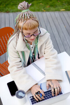 Young Woman Jotting Ideas Outside