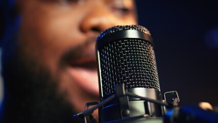 Artist records his voice on microphone in home studio singing a song composed by him. Skilled...