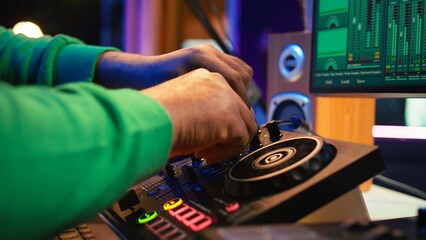 Audio engineer with headset mixing and mastering his recorded files, operating on a professional...