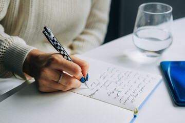 Close up of female hand handwriting in a notebook
