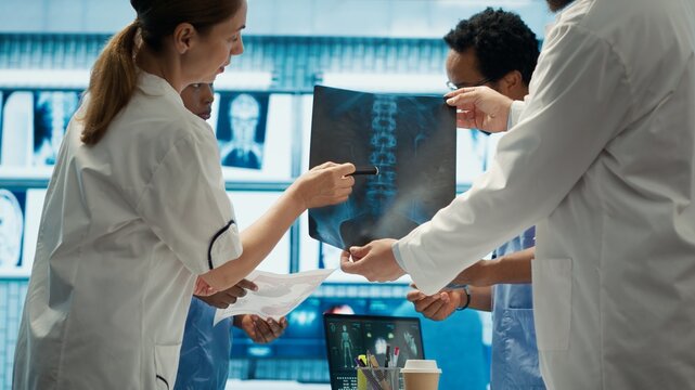 Doctors analyze human anatomy scans in a treatment center, teamwork and expertise in radiology and diagnostics. Medical professionals ensure disease prevention and control. Camera A.