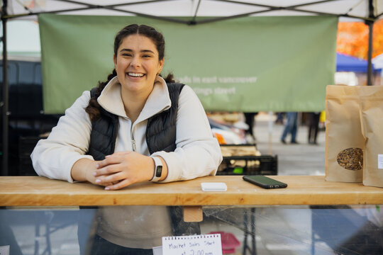 Smiling Vendor at Local Farmers Market Bakery Stall