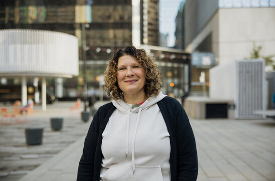 Confident Woman Smiling Outdoors in Urban Environment