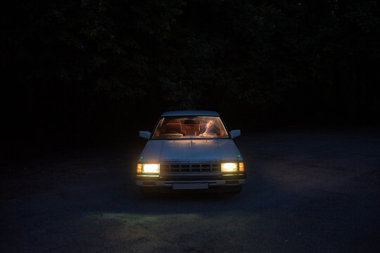A cinematic shot of a car and the woman inside.
