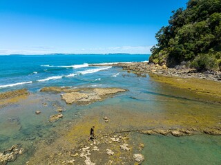 Coastal explorer on a sunny day. A person explores the shallows of a beautiful bay. Clear water and...