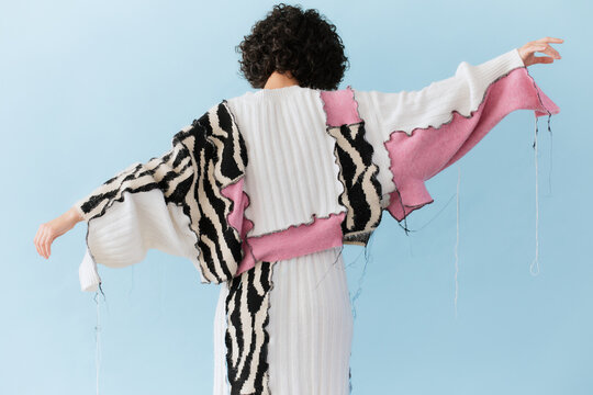 Woman in Colorful Knitwear Posing with Outstretched Arms