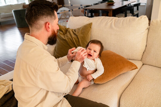Dad putting clothes on toddler