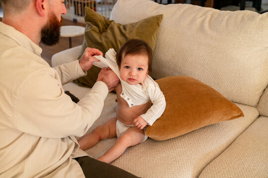 Dad putting clothes on toddler