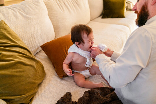Dad putting clothes on toddler