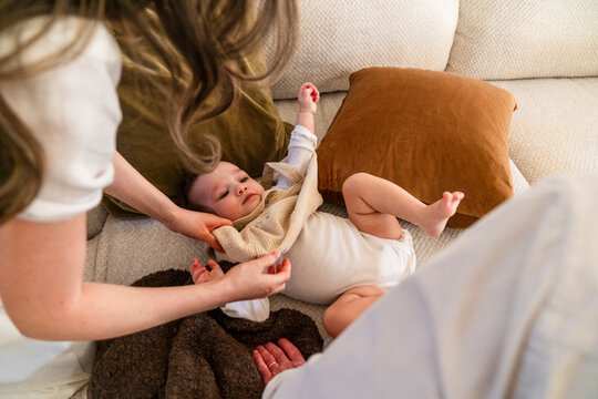 parents changing baby clothing