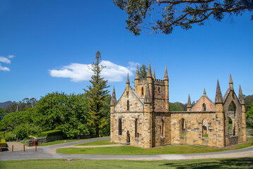 Ruins of an old church in Port Arthur, Tasmania, Australia, with Gothic architecture and lush green...