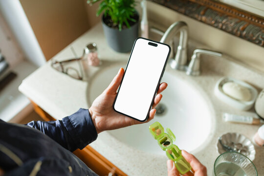  The woman uses a mobile phone with white screen and takes pills