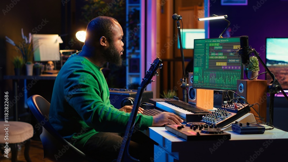 Poster Musical producer prepares to record tunes on acoustic instrument, working in personal home studio to record soundtrack. Sound composer recording guitar music, editing with mixing console. Camera A.