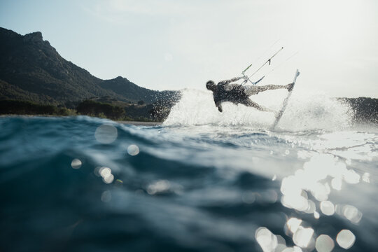 Kitesurfer sliding and pressing his board in the waves 